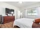 Main bedroom featuring a dresser with a television and a comfortable bed, creating a cozy retreat at 17552 W Young St, Surprise, AZ 85388