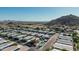 Community aerial view of home exteriors with a kidney bean shaped community pool and desert views at 2233 E Behrend Dr # 210, Phoenix, AZ 85024