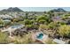 Aerial view of two uniquely shaped pools with seating areas surrounded by desert landscape and neighborhood at 2233 E Behrend Dr # 210, Phoenix, AZ 85024
