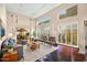 Bright living room with hardwood floors, high ceilings, plantation shutters, and large windows showcasing the outdoor view at 6711 E Camelback Rd # 21, Scottsdale, AZ 85251