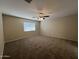 Spacious carpeted bedroom with ceiling fan and large window at 310 S 113Th Dr, Avondale, AZ 85323