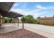 Backyard covered patio featuring decorative metal pillars, leading to a concrete patio with lush landscaping at 3425 W Acoma Dr, Phoenix, AZ 85053
