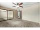Spacious bedroom with a ceiling fan, large closet, and carpeted floors, providing ample storage and comfort at 3425 W Acoma Dr, Phoenix, AZ 85053