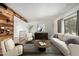 Comfortable living room with a cozy seating arrangement, natural wood wall accents, and ample natural light from the window at 3425 W Acoma Dr, Phoenix, AZ 85053