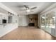 Open-concept living room with a brick fireplace and a sliding glass door to the backyard at 3425 W Acoma Dr, Phoenix, AZ 85053