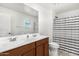 Clean bathroom with double vanity and striped shower curtain at 25677 W Siesta Way, Buckeye, AZ 85326
