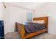 Bedroom with a wooden sleigh bed and large window at 25677 W Siesta Way, Buckeye, AZ 85326