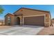 Tan house with brown garage door and landscaping at 25677 W Siesta Way, Buckeye, AZ 85326