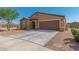 Tan house with brown garage door and landscaping at 25677 W Siesta Way, Buckeye, AZ 85326