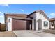 Single-story home featuring a two-car garage, a brown tile roof, stucco walls, and desert landscaping at 7552 W Park St, Laveen, AZ 85339