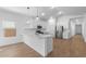 Bright kitchen featuring an island, stainless steel appliances, white cabinets, and hardwood flooring at 7552 W Park St, Laveen, AZ 85339
