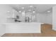 A kitchen with white cabinetry, hardwood floors, stainless steel appliances, and a kitchen island at 7552 W Park St, Laveen, AZ 85339
