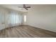 This spacious bedroom features a ceiling fan, soft natural light, and stylish wood-look floors at 27571 N 171St Dr, Surprise, AZ 85387