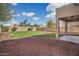 Spacious backyard with grassy area and a covered patio at 3834 E Cavalry Ct, Gilbert, AZ 85297