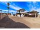 Large backyard with dirt landscaping and a white home with a blue sky backdrop at 728 W Grove Cir, Mesa, AZ 85210