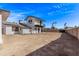 Large backyard with a two-story house and partial fence offers ample space for outdoor activities at 728 W Grove Cir, Mesa, AZ 85210