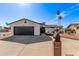 Charming single-story home with a black garage door, well-maintained lawn, and mature palm trees at 728 W Grove Cir, Mesa, AZ 85210