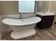 Elegant bathroom featuring a freestanding soaking tub and dark wood vanity at 29923 W Melvin St, Buckeye, AZ 85396