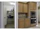 Well-equipped kitchen featuring wooden cabinetry, stainless steel microwave and oven, and pantry at 786 W Jahns Dr, Casa Grande, AZ 85122
