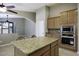 Kitchen featuring a granite island, wood cabinets, and a view into the living and dining areas at 786 W Jahns Dr, Casa Grande, AZ 85122