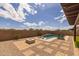 Resort-style backyard featuring a sparkling pool with lounge chairs, lush greenery, and a cozy fire pit area at 10331 E Wavelength Ave, Mesa, AZ 85212