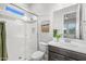 Bathroom features a glass shower, white tiles, dark vanity, and green accents at 10331 E Wavelength Ave, Mesa, AZ 85212