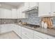 A well-lit kitchen shows white cabinets, a gray backsplash, and a stainless steel stove top at 10331 E Wavelength Ave, Mesa, AZ 85212