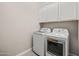 Functional laundry area with washer, dryer, and white upper cabinets at 10331 E Wavelength Ave, Mesa, AZ 85212