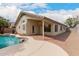The backyard features a covered patio with a walkway connecting to a freeform pool with a rock feature at 10209 W Jessie Ln, Peoria, AZ 85383