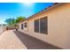 Paver patio alongside the house leads to a jacuzzi, mature tree, and view of the home's exterior at 10209 W Jessie Ln, Peoria, AZ 85383