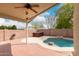 Backyard oasis featuring a covered patio with fan, spa, and rock waterfall pool at 10209 W Jessie Ln, Peoria, AZ 85383