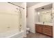 Cozy bathroom with a shower-tub combo, oak vanity, and wood-look floors at 10209 W Jessie Ln, Peoria, AZ 85383
