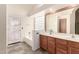 Bright bathroom featuring double sinks, vanity, tub, and decorative glass block at 10209 W Jessie Ln, Peoria, AZ 85383
