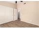 Bright bedroom with wood-look floors, a ceiling fan, a closet, and a hallway view at 10209 W Jessie Ln, Peoria, AZ 85383