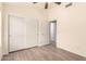 Neutral bedroom featuring a ceiling fan, wood-look floors, closet, and white trim throughout at 10209 W Jessie Ln, Peoria, AZ 85383
