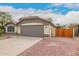 Exterior view showcasing the home's well-maintained landscaping, a two-car garage, and a private gate at 10209 W Jessie Ln, Peoria, AZ 85383