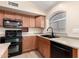 Traditional kitchen featuring wood cabinetry, black appliances, and a stylish sink fixture at 10209 W Jessie Ln, Peoria, AZ 85383
