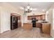 Charming kitchen with stainless steel refrigerator, kitchen island, wood floors, and modern light fixture at 10209 W Jessie Ln, Peoria, AZ 85383