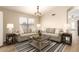 Bright living room featuring neutral sofas, striped rug, and a square wooden coffee table at 10209 W Jessie Ln, Peoria, AZ 85383