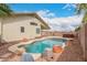A freeform pool is surrounded by rock landscaping, and a covered patio with a jacuzzi in the background at 10209 W Jessie Ln, Peoria, AZ 85383