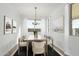 Elegant dining room featuring a modern chandelier, neutral decor, and ample natural light from large windows at 16173 S 181St Ave, Goodyear, AZ 85338