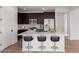 Contemporary kitchen with dark wood cabinets, stainless steel appliances, and a quartz countertop island with seating at 16173 S 181St Ave, Goodyear, AZ 85338
