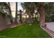 A lush backyard featuring a fountain, wrought iron fence and mature landscaping at 760 N Ithica St, Gilbert, AZ 85233