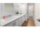 Bright bathroom with double sinks, white cabinets, quartz countertop, and tiled wall with a view of a tub at 760 N Ithica St, Gilbert, AZ 85233