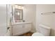 Cozy powder room with white cabinetry, modern fixtures, and a framed mirror at 760 N Ithica St, Gilbert, AZ 85233