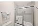 A modern bathroom featuring a bathtub and shower combination with a glass sliding door at 760 N Ithica St, Gilbert, AZ 85233