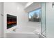 Bright bathroom featuring a soaking tub, walk-in shower, and a fireplace at 760 N Ithica St, Gilbert, AZ 85233