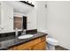 Bathroom featuring granite countertop, wood cabinets, and tile shower at 10030 W Indian School Rd # 218, Phoenix, AZ 85037