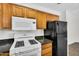 Functional kitchen featuring gas range, microwave, wood cabinets, and efficient refrigerator at 10030 W Indian School Rd # 218, Phoenix, AZ 85037