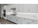 Detailed view of a kitchen with a cooktop, white cabinets, quartz countertops, and stainless steel appliances at 11691 N Luckenbach St, Surprise, AZ 85388